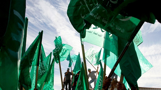 Palestinci s vlajkami hnutí Hamas oèekávají u Ramaláhu pøíjezd propuštìných...