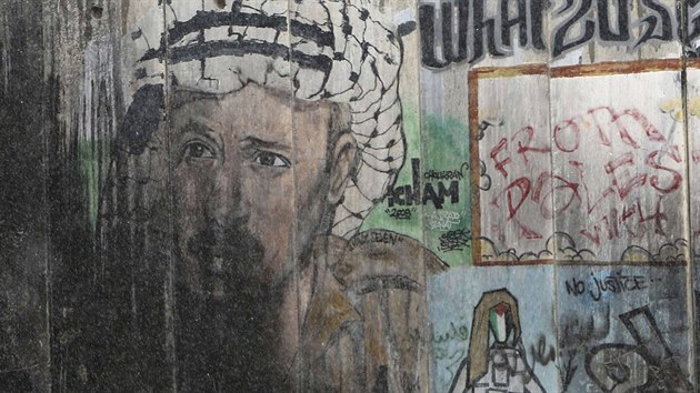Policisté procházejí kolem grafiti s Jásirem Arafatem v Ramalláhu (31. øíjna 2014).