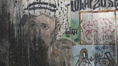 Policisté procházejí kolem grafiti s Jásirem Arafatem v Ramalláhu (31. øíjna...