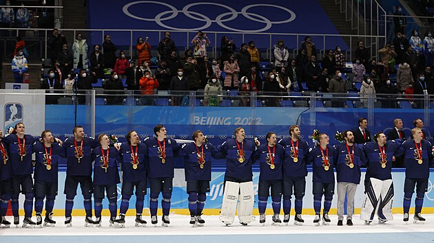 Finští hokejisté si bìhem ceremoniálu po vítìzství v olympijském finále s medailemi na krku zpívají národní hymnu