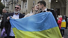 Novomanželé drží ukrajinskou vlajku, lidé se shromažïují v centru mìsta na...
