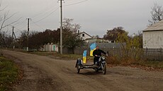 Uèitel Jurij Nevolèuk jede na motocyklu s národními vlajkami ve vesnici...