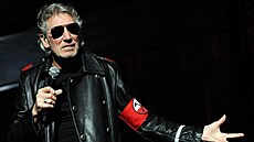 Roger Waters v èerném kabátì s èervenou páskou na paži.