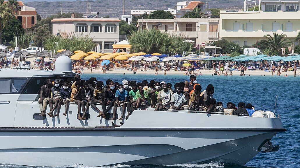 Migranti pøiplouvají na lodi Guardia di Finanza v pøístavu italského ostrova...