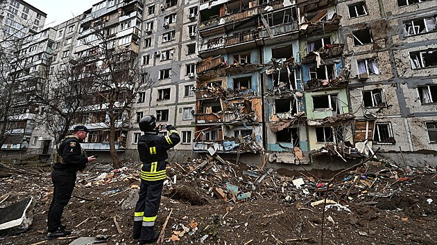 Èlen záchranného týmu fotografuje obytný dùm poškozený pøi ruském raketovém útoku v Záporoží na Ukrajinì. (22. bøezna 2024)
