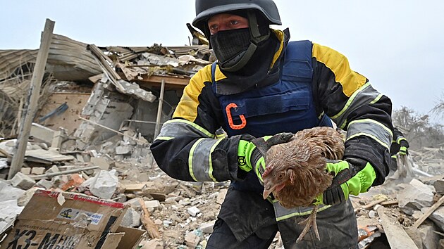 Èlen záchranného týmu mezi troskami na místì obytných budov znièených ruským raketovým úderem v Záporoží (22. bøezna 2024)