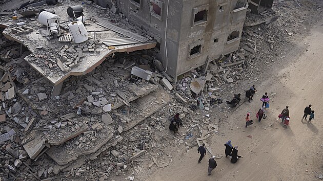 Palestinci procházejí znièenými budovami po izraelské letecké a pozemní ofenzivì v Chán Júnisu na jihu Pásma Gazy. (8. dubna 2024)
