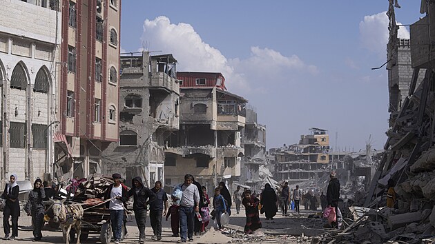 Palestinci procházejí znièenými budovami po izraelské letecké a pozemní ofenzivì v Chán Júnisu na jihu Pásma Gazy. (8. dubna 2024)