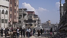 Palestinci procházejí znièenými budovami po izraelské letecké a pozemní...