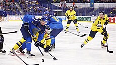 Švéd Joel Eriksson Ek v souboji o puk s Maximem Mukhametovem.