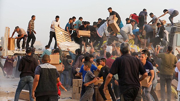 Palestinci berou krabice s humanitární pomocí z nákladních aut pøevážejících...